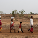Bhaagi (L) and Sakhri (2nd from L), wives of Sakharam Bhagat (R) walk to fetch water from a well